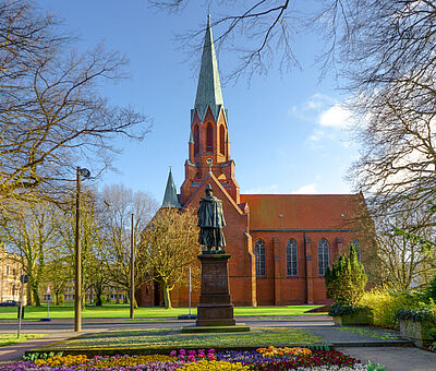 Außenaufnahme der Christus- und Garnisonkirche, im Vordergrund steht das Denkmal von Kaiser-Wilhelm