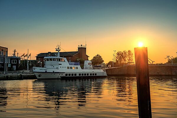 Hafenrundfahrten an der Nordsee - Das Passagierschiff Harle Kurier bei Sonnenuntergang in Wilhelmshaven 